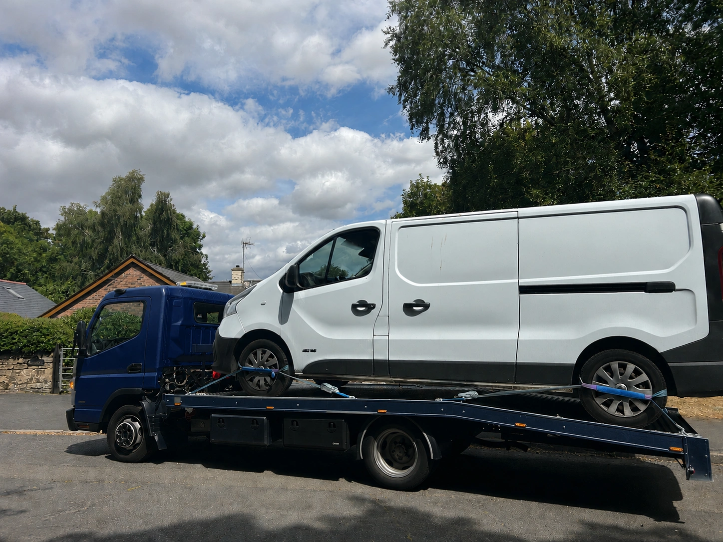 Dark blue recovery truck carrying a white van, Van Recovery Services UK